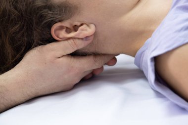 Osteopat doktor boyun bölgesiyle ve hastanın başıyla çalışıyor. Yakından bak, masör.