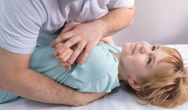 Ein Osteopath arbeitet mit dem Kind. Arbeiten Sie mit Brust, Schultern und Wirbelsäule. Auf der Couch liegt ein Teenager. Der Arzt übt Druck auf die Brust des Patienten aus. Haltungskorrektur — Stockfoto