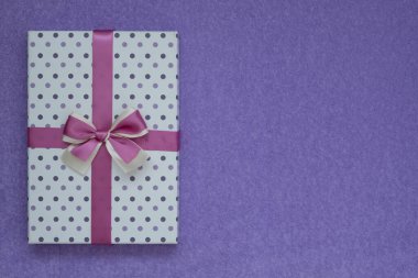 Yukarıdan bak. Mor süet arka planda güzel bir hediye kutusu. Metin için boşluk var