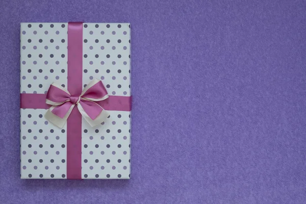 Vista desde arriba. Hermosa caja de regalo sobre un fondo de ante púrpura. Hay espacio para el texto — Foto de Stock