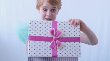 Güzel bir gece elbisesi giymiş genç bir kız. Çocuk hediyeyle birlikte kutuyu açar. Kutudaki sürprizden gelen şaşkınlık ve mutluluk duyguları.