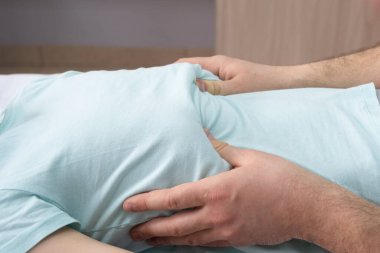 Bir osteopatın çalışma süreci. Doktor hastanın arkasındadır. Kaburga işi. Göğüs düzeltmesi. Yakın plan..