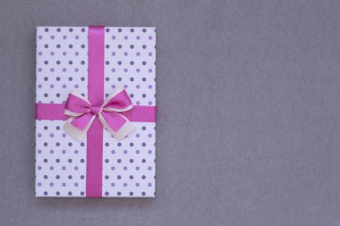 Yukarıdan bak. Gri arka planda güzel bir hediye kutusu. Metin için yer var.