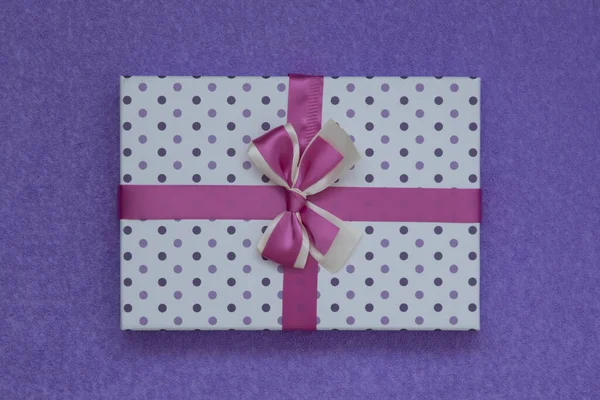 Vista desde arriba. Hermosa caja de regalo sobre un fondo de ante púrpura. Hay espacio para el texto — Foto de Stock
