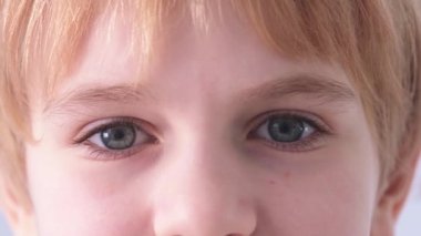 Childs 'ın gözleri çok yakın. Mavi gözlü bir çocuk kameraya bakıyor. Kızıl saçlı liseli kız ya da erkek öğrenci..