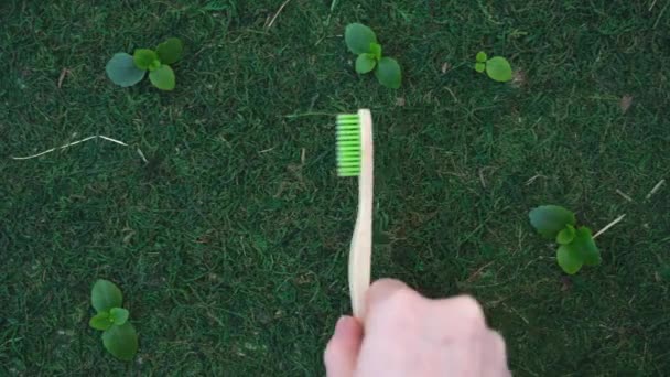 Umweltfreundliche Zahnbürste. Zahnbürste auf natürlichem Hintergrund. Moos und Gras. Ökologisches Pflegekonzept — Stockvideo