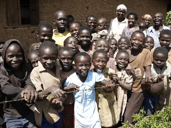 Eine Gruppe afrikanischer Kinder lächelt hinter der Stacheldrahtzäune. — Stockfoto