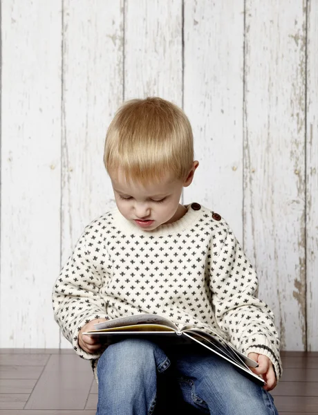 Küçük çocuk kitap okuyor.