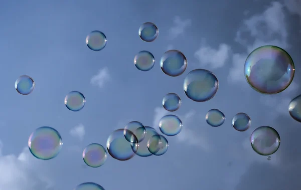 Soplando burbujas de jabón en el cielo y las nubes Imagen De Stock