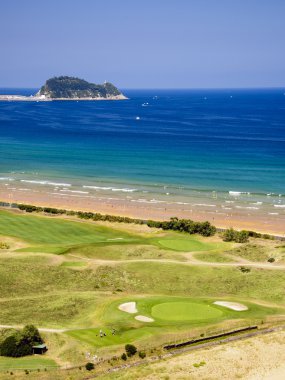 Beach and golf course of Zarautz with Guetaria on the background clipart