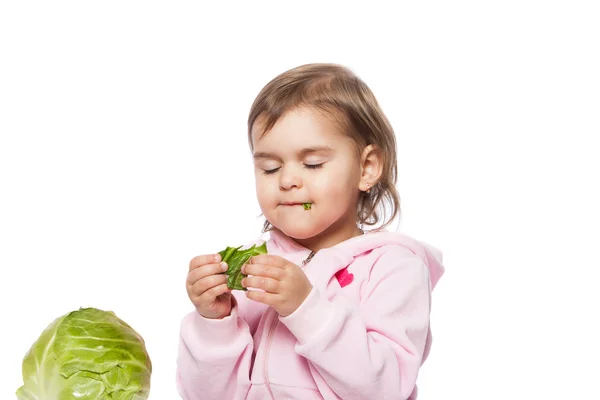 Little girl eating cabbage — Stock Photo, Image