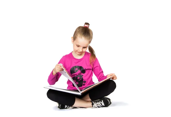 Menina lendo um livro sobre fundo branco — Fotografia de Stock