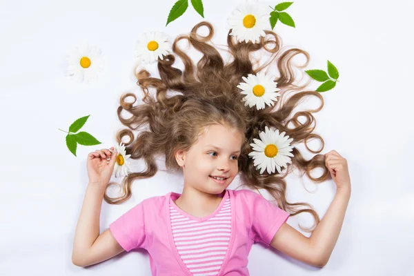 Chica acostada con flores en su pelo — Foto de Stock