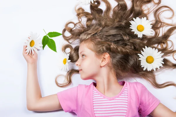 Girl lying with flowers in her hair — Stock Photo, Image