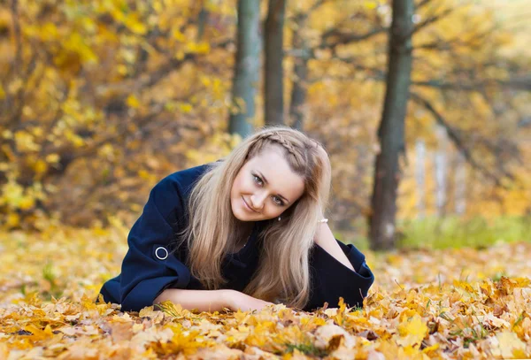 Молодая женщина в желтом осеннем парке — стоковое фото