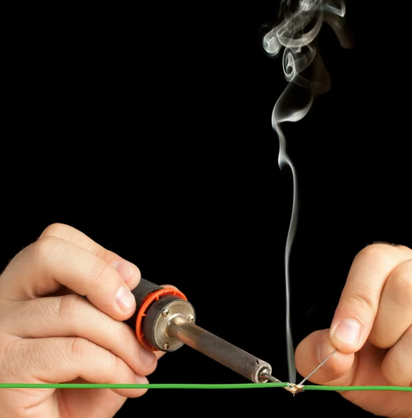 Technician soldering two wires together on a black background. — Stock Photo, Image