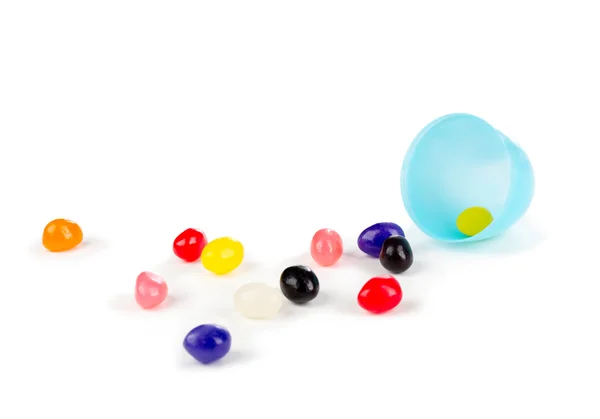 Colorful jelly beans spilled out of a plastic Easter egg. — Stock Photo, Image