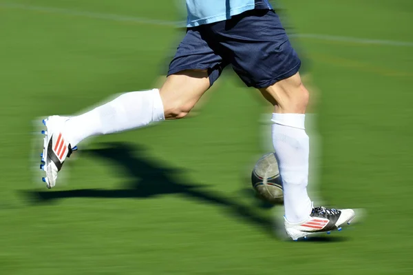 Jogador de futebol correndo com bola Fotos De Bancos De Imagens Sem Royalties