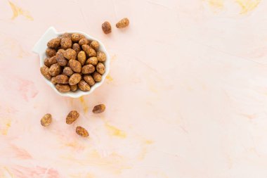 Şekerli ya da şekerli badem, pembe arka planda porselen tabakta.