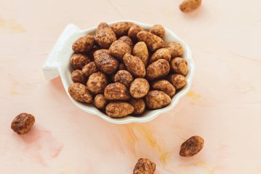 Şekerli ya da şekerli badem, pembe arka planda porselen tabakta.