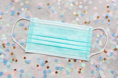 Mavi cerrahi maske ve renkli konfeti.