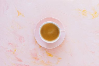 Pembe arka planda bir fincan espresso.