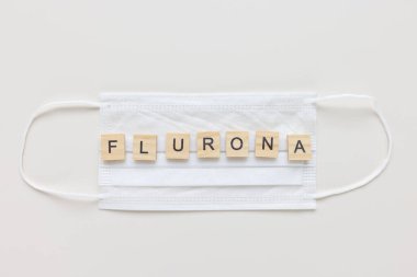FLURONA maskeli, beyaz arkaplan. COVID ve grip çift enfeksiyon konsepti