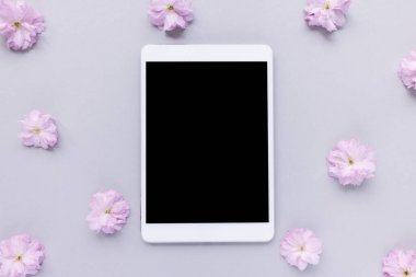 Bahar çiçeklerinin arka planında dijital tablet