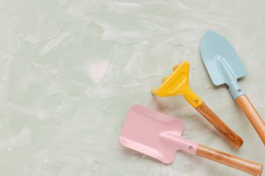 Yeşil arka plandaki esrar bitkileri için küçük bahçe aletleri. Küçük kürek ve tırmıklar.