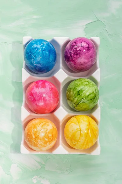 Oeufs de Pâques multicolores dans une boîte d'organisateur de rangement en porcelaine sur fond vert — Photo