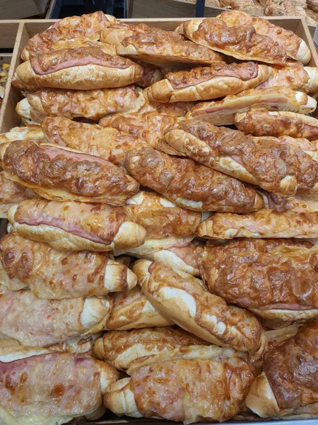 Rolos rohlik checos brancos recém-assados com bacon e queijo derretido, chamados rohlik inglês na padaria — Fotografia de Stock