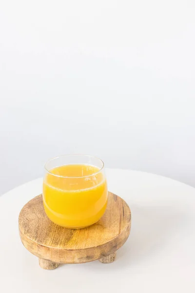 Fresh squeezed orange juice in glass on table on white background. Healthy beverage for breakfast — Stock Photo, Image