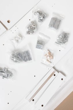 Box with furniture assembly parts and bolts and screws on the floor. Self assembling folding table