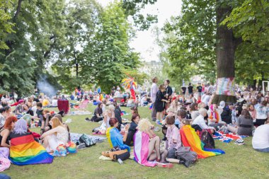 Yıllık Prag Onur Festivali 'nde Strelecky Adası' ndaki Pride Village 'da düzenlenen piknik etkinliğinde gökkuşağı ve diğer gurur bayrakları olan insanlar. Prag, Çek Cumhuriyeti - 7 Ağustos 2021