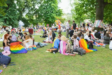 Prague, Czech Republic - August 7, 2021. People with rainbow and other Pride flags at picnic event at the Pride Village on Strelecky Island at annual Prague Pride festival
