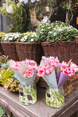 Tulips, heather, chrysanthemum and hanging flowers and wreaths at the flower shop. Halloween and Thanksgiving autumn decoration with flowers in trendy rattan baskets