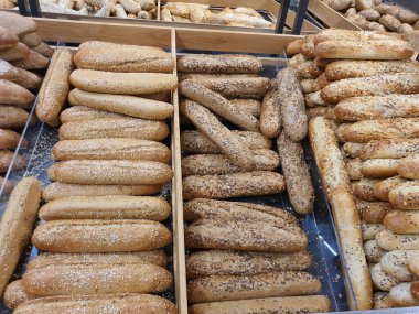 Fırında ya da bakkalda kahverengi ve altın keten tohumlu farklı Fransız ekmeği çeşitleri. Taze pişmiş ekmek.