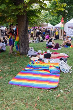 Yıllık Prag Onur Festivali 'nde Strelecky Adası' ndaki Pride Village 'da düzenlenen piknik etkinliğinde gökkuşağı ve diğer gurur bayrakları olan insanlar. Prag, Çek Cumhuriyeti - 7 Ağustos 2021