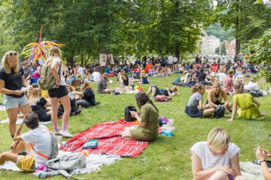 Yıllık Prag Onur Festivali 'nde Strelecky Adası' ndaki Pride Village 'da düzenlenen piknik etkinliğinde gökkuşağı ve diğer gurur bayrakları olan insanlar. Prag, Çek Cumhuriyeti - 7 Ağustos 2021