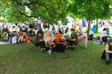 Yıllık Prag Onur Festivali 'nde Strelecky Adası' ndaki Pride Village 'da düzenlenen piknik etkinliğinde gökkuşağı ve diğer gurur bayrakları olan insanlar. Prag, Çek Cumhuriyeti - 7 Ağustos 2021