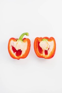 Taze olgun kırmızı dolmalık biber beyaz arka planda ikiye bölünmüş. Sağlıklı vejetaryen yemekleri ve yemek pişirme konsepti. Yakın plan, kopyalama alanı