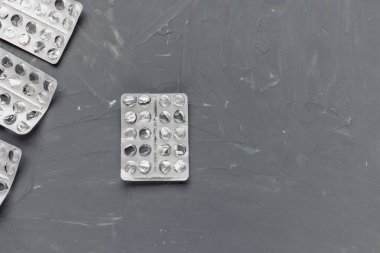 Gri arka planda boş ilaç paketleri, takviye ve ilaç konsepti. Yakın çekim, üst görünüm, kopyalama alanı