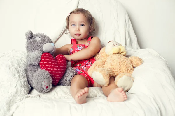 Bebé en el sofá con juguetes — Foto de Stock