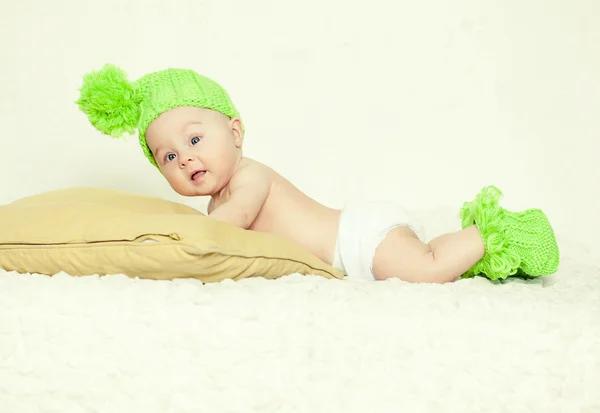 Грустный ребенок в зеленой кепке и тапочках — стоковое фото