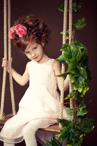 Mooi roodharig meisje op een schommel. — Stockfoto
