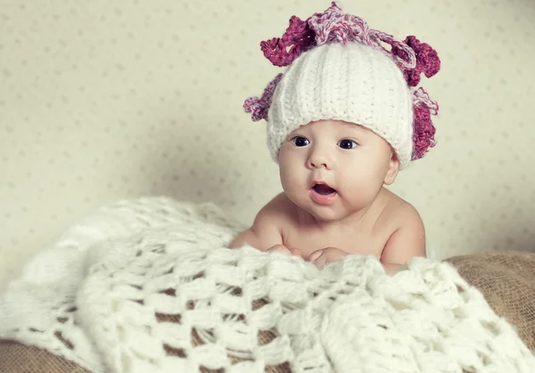 Foto de um bebê com a boca aberta em um chapéu branco — Fotografia de Stock