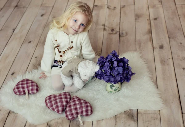 En liten flicka som sitter på golvet. — Stockfoto