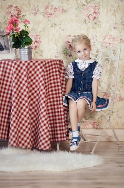 Chica modesta sentada en la mesa . — Foto de Stock
