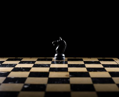 Tahta bir tahtanın üzerinde çeşitli ışıklarla tahta satranç taşları..