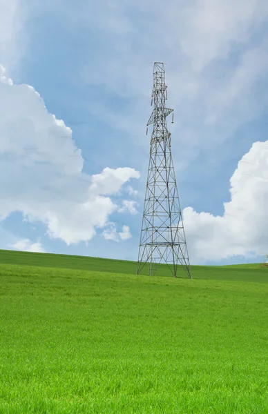 Yüksek gerilim kuleleri ve kablolar üzerinde mavi bir gökyüzü tarım alanları — Stok fotoğraf